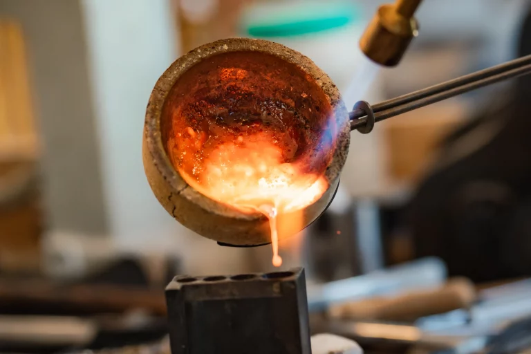 Flammende Schmelzschale mit glühendem Metall in der Goldschmiede-Werkstatt